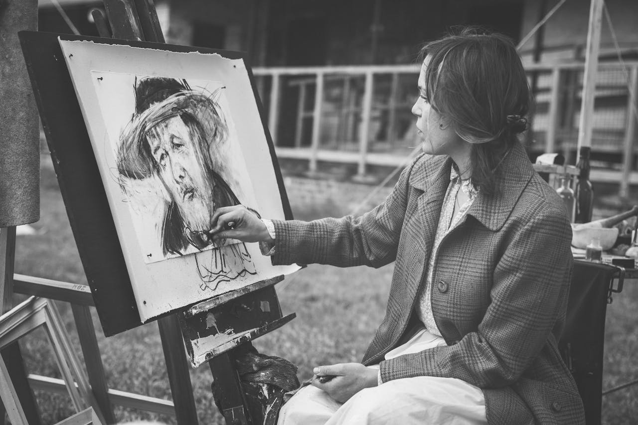 Services-02 Woman painting a portrait outdoors in black and white.